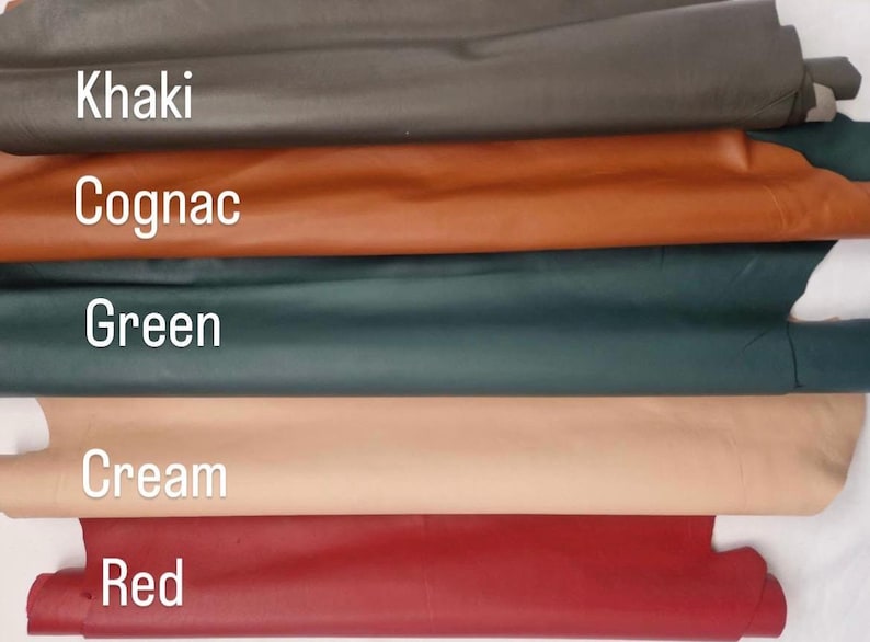 May include: A selection of leather swatches in various colors, including Khaki, Cognac, Green, Cream, and Red. The names of the colors are displayed in white text over each swatch. The leather appears smooth and has a slight sheen.