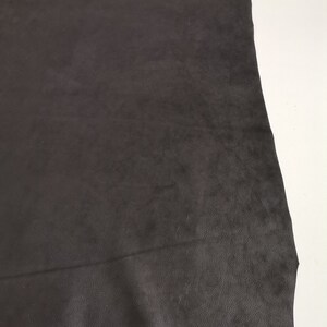May include: A piece of black leather with a smooth, textured surface.