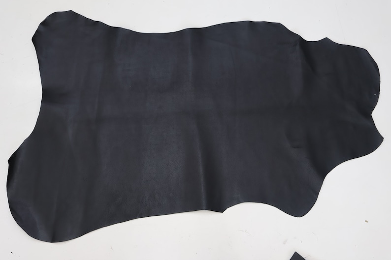 K&ouml;nnte beinhalten: Ein gro&szlig;es St&uuml;ck schwarzes Leder mit unregelm&auml;&szlig;iger Form.