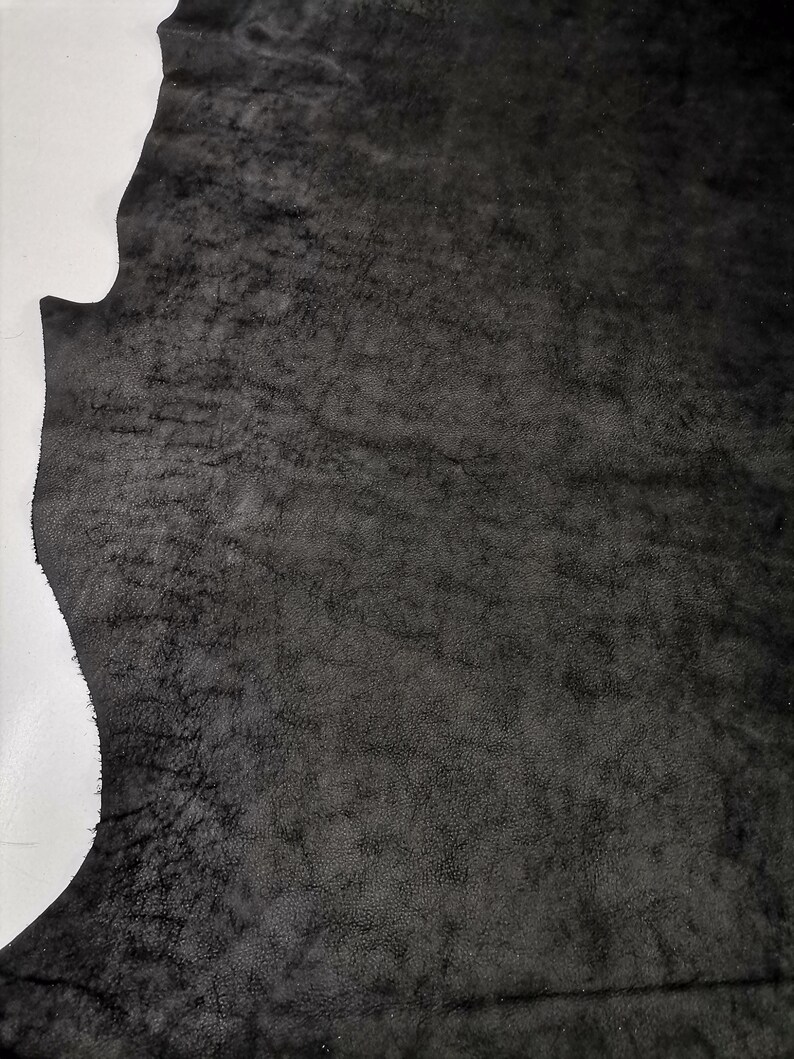 May include: A piece of black leather with a textured surface.