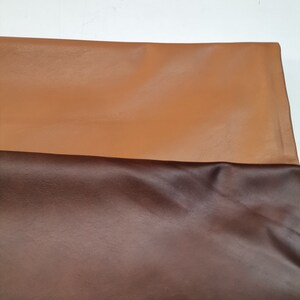 Peut inclure: Deux morceaux de cuir, l'un brun et l'autre brun fonc&eacute;, sont dispos&eacute;s sur une surface blanche.