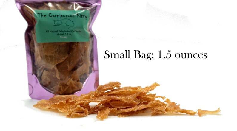 May include: A small purple bag with a label that reads "The Carnivorous Kitty" and "All Natural Dehydrated Cat Treats Turkey Net wt. 1.5 oz" with a pile of thin, light brown, dehydrated turkey cat treats in front of the bag. Small Bag: 1.5 ounces