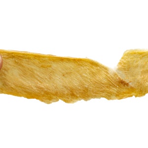 May include: A thin, light brown, dried fish skin snack.