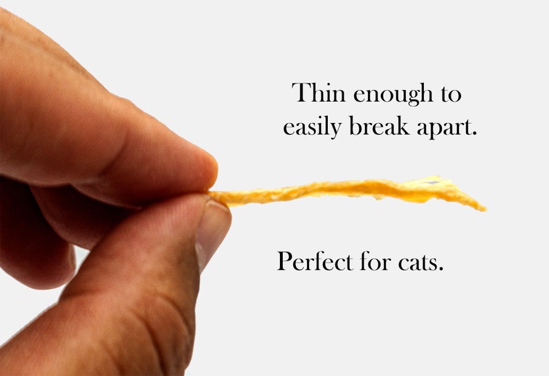 Puede incluir: Un premio de carne seca delgado y de color marr&oacute;n claro se sostiene entre dos dedos. El premio es lo suficientemente delgado como para romperse f&aacute;cilmente. El texto "Lo suficientemente delgado como para romperse f&aacute;cilmente. Perfecto para gatos." est&aacute; debajo de la imagen.
