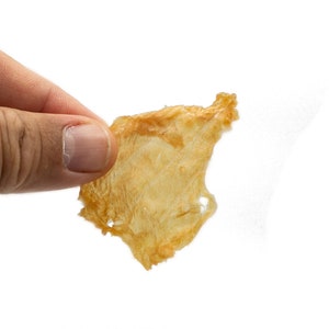May include: A single, light brown, crispy, dried fish skin snack.