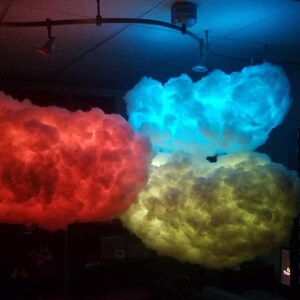 May include: Three fluffy cloud-shaped lamps with red, blue, and yellow LED lights. The lamps are hanging from the ceiling.