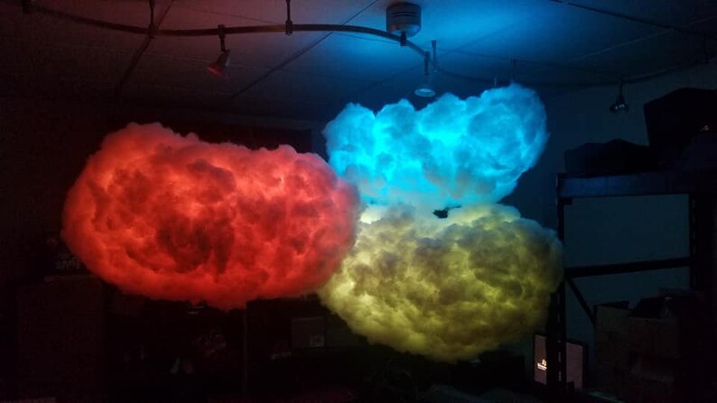 May include: Three fluffy cloud-shaped lamps with red, blue, and yellow LED lights. The lamps are hanging from the ceiling.