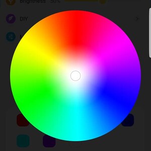 May include: A smartphone screen displaying a color wheel with a slider below it. The color wheel is a circular gradient of colors from red to orange, yellow, green, blue, indigo, and violet. The slider is a horizontal bar with a green dot in the middle. The text "Color Wheel" is below the slider. The text "Brightness: 50%" is above the color wheel.