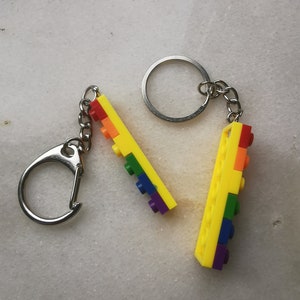 May include: A rainbow-colored keychain made of Lego bricks attached to a silver key ring.