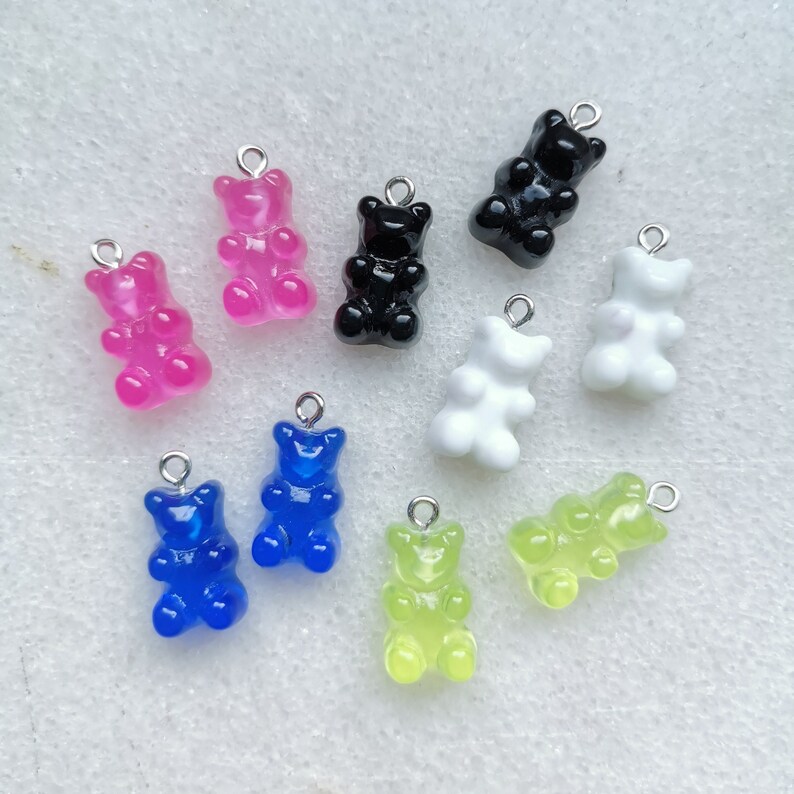 K&ouml;nnte beinhalten: Sortiment von zehn Gummib&auml;rchen-Anh&auml;ngern in verschiedenen Farben, darunter rosa, schwarz, wei&szlig;, blau, gr&uuml;n und gelb. Jeder Anh&auml;nger hat eine silberne Schlaufe zum Anbringen an einer Halskette, einem Armband oder anderem Schmuck.