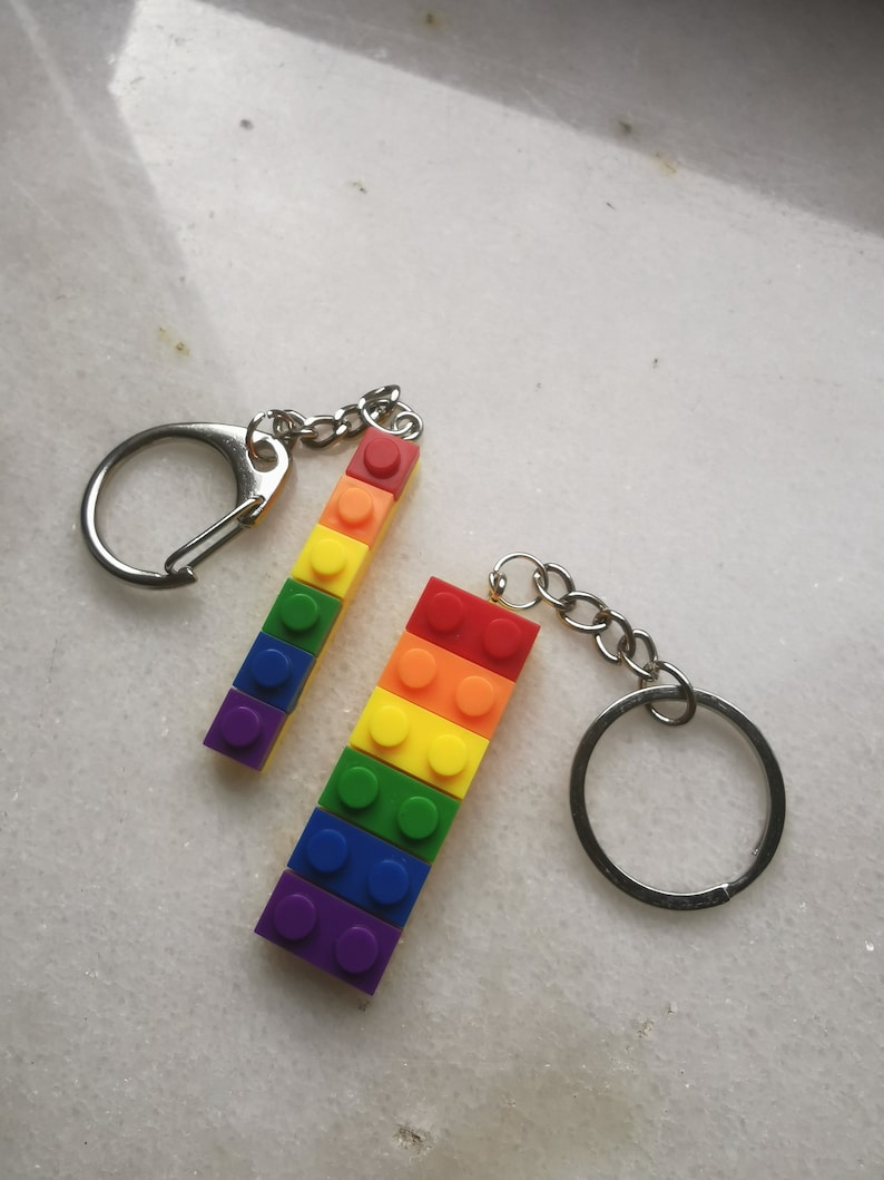 May include: Two rainbow-colored keychain charms made of plastic building blocks. Each charm is attached to a silver key ring.