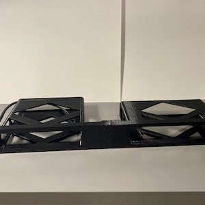 May include: Black rack mount server enclosure with a geometric design. The enclosure has a rectangular shape with diamond-shaped cutouts and a section for a network cable. The server enclosure is designed to hold electronic components.