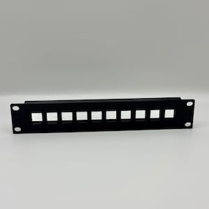 May include: A black, rectangular patch panel with ten square openings. The panel has two holes on each end for mounting. The item is designed for network or data cable management.
