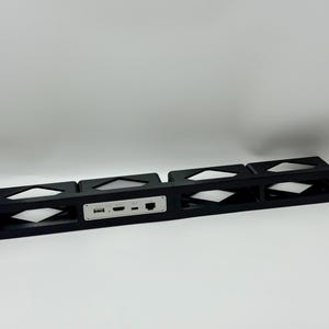 Puede incluir: Un panel de montaje en rack negro con cuatro aberturas rectangulares y un módulo de interfaz central plateado. El módulo incluye un puerto USB, un puerto HDMI, un puerto USB-C y un puerto Ethernet. El panel tiene orificios de montaje.
