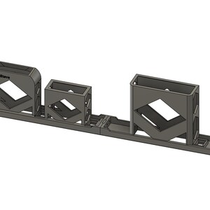 Könnte beinhalten: Ein graues 3D-gedrucktes Objekt mit drei rechteckigen Fächern unterschiedlicher Größe, die durch eine Basis verbunden sind. Jedes Fach hat einen rautenförmigen Ausschnitt. Der Text "Print3Dwave" ist auf dem größten Fach sichtbar.