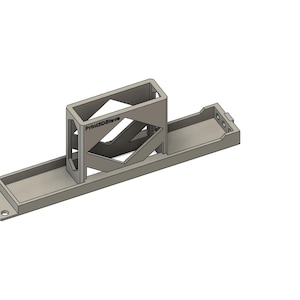 Puede incluir: Soporte metálico gris claro, renderizado en 3D, con una base rectangular y una estructura central de marco abierto. El diseño incluye soportes angulados y una pequeña bandeja rectangular. El texto "Print2Design" es visible.