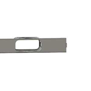 Puede incluir: Un componente metálico de color plateado con un cuerpo rectangular y una gran abertura rectangular redondeada. Dos pequeños agujeros circulares son visibles en un extremo. El componente tiene una sección curva elevada cerca de la abertura.