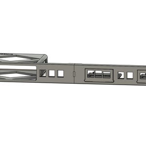 May include: A gray metal network rack mount with multiple rectangular and square openings. The rack features a series of ports and a structured design, suitable for organizing and securing network equipment. The design includes a section with diamond-shaped cutouts.