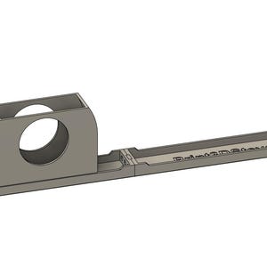 May include: A light gray 3D-printed object with a rectangular base and a curved, cylindrical component. The object has a hollow circular opening and the text "Relive3D.Store" is visible on the side. The design appears to be a custom-made component.