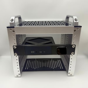 以下が含まれることがあります： 前面に黒いコンポーネントが取り付けられたシルバーの金属製ラック。ラックは、穴あきの上部とハンドルを備えた2つのレベルがあります。前面のコンポーネントには、USBポートと電源ボタンがあります。ラックは電子機器を収納するように設計されています。