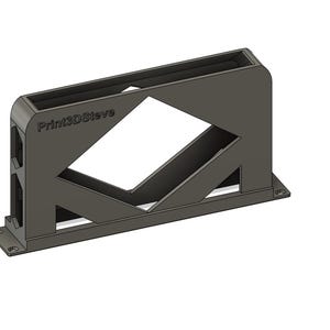 Op de afbeelding: Een donkergrijze 3D-geprinte bureau-organizer met een geometrisch ontwerp. De organizer heeft een rechthoekige vorm met een grote ruitvormige uitsparing en de tekst "Print3DSteve" aan de zijkant. Het heeft een platte basis met montagegaten.