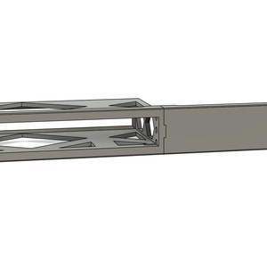 Könnte beinhalten: Ein graues Metallgestell mit einer rechteckigen Öffnung und einer massiven Platte auf der rechten Seite. Das Gestell hat ein dekoratives Muster aus Dreiecken und Quadraten.