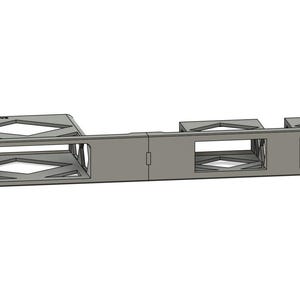 Op de afbeelding: Een grijs metalen rackmount-component met meerdere rechthoekige openingen en ruitvormige uitsparingen. Het component heeft een reeks rechthoekige openingen en ruitvormige uitsparingen en is ontworpen om in een racksysteem te worden gemonteerd.