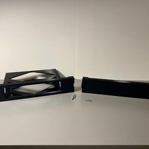 May include: Two black plastic pieces for a 3D printed rack, with two screws and two washers.