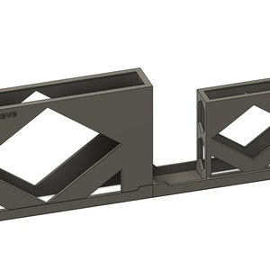 Puede incluir: Un objeto gris impreso en 3D con un diseño geométrico. El objeto tiene una base rectangular y dos secciones verticales con espacios abiertos. El texto "Print3DSby" es visible en el objeto.