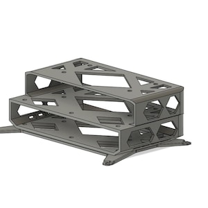 May include: A two-tiered, gray metal shelf with geometric cutouts. The shelf has a rectangular shape with a series of holes and angled supports. The design includes a series of geometric shapes and is elevated on small feet.