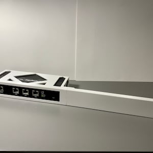 May include: White network router with a black front panel featuring multiple ethernet ports. The router is connected to a white metal rack.