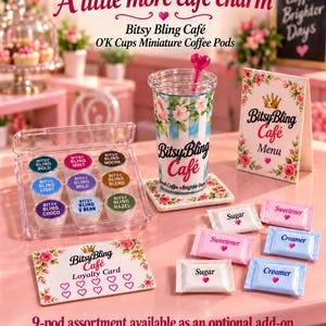 May include: A miniature Bitsy Bling Caf&eacute; set featuring a clear tumbler with a pink heart stirrer, a menu, a loyalty card, and nine coffee pods labeled Bold, Mint, Mocha, Light, Mild, Blend, Choco, V Bean, and Hazel, plus sugar and creamer packets.