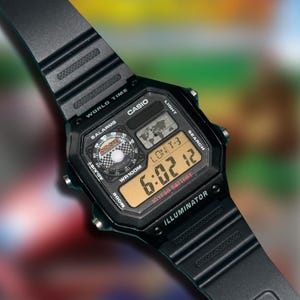 May include: Black digital Casio watch with a rectangular face and black band. The watch displays the time, date, and other functions on a digital screen. The watch has the text "CASIO", "WORLD TIME", and "ILLUMINATOR" printed on the face.