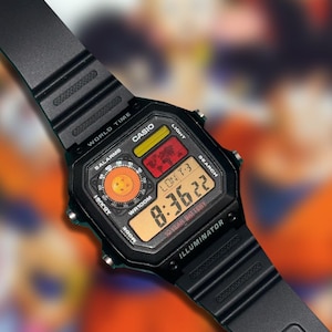 May include: A black digital Casio Illuminator wristwatch with a resin strap. The square face features a world map display, a circular orange graphic with four stars, and a digital screen showing the time 8:36:22 with the text 10 YEAR BATTERY.