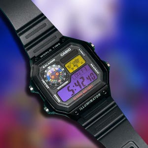 May include: Black Casio digital watch with a custom face featuring a Majora's Mask design. The watch displays the time 5:42:40 on a purple screen. It has multiple function buttons and a black resin band.