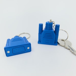 May include: Two blue VGA connector keychains with silver key rings and a silver key. The keychains are a bright blue color and have a detailed design. The keychains are on a white background.