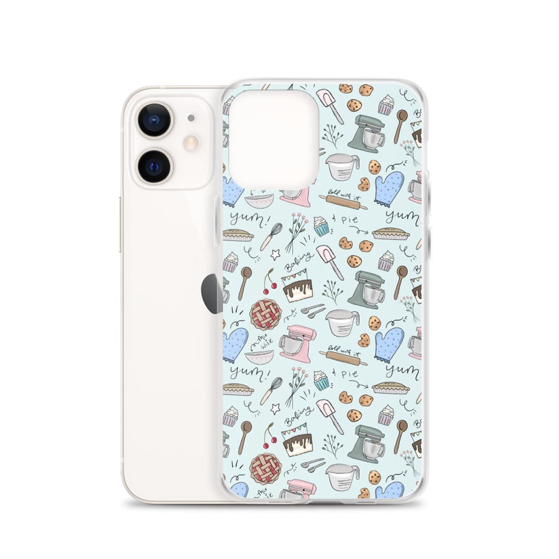 May include: A clear phone case with a light blue background and a pattern of baking-themed illustrations. The illustrations include a mixer, a pie, a cupcake, a cherry, a rolling pin, a spatula, and the words "yum!" and "baking".