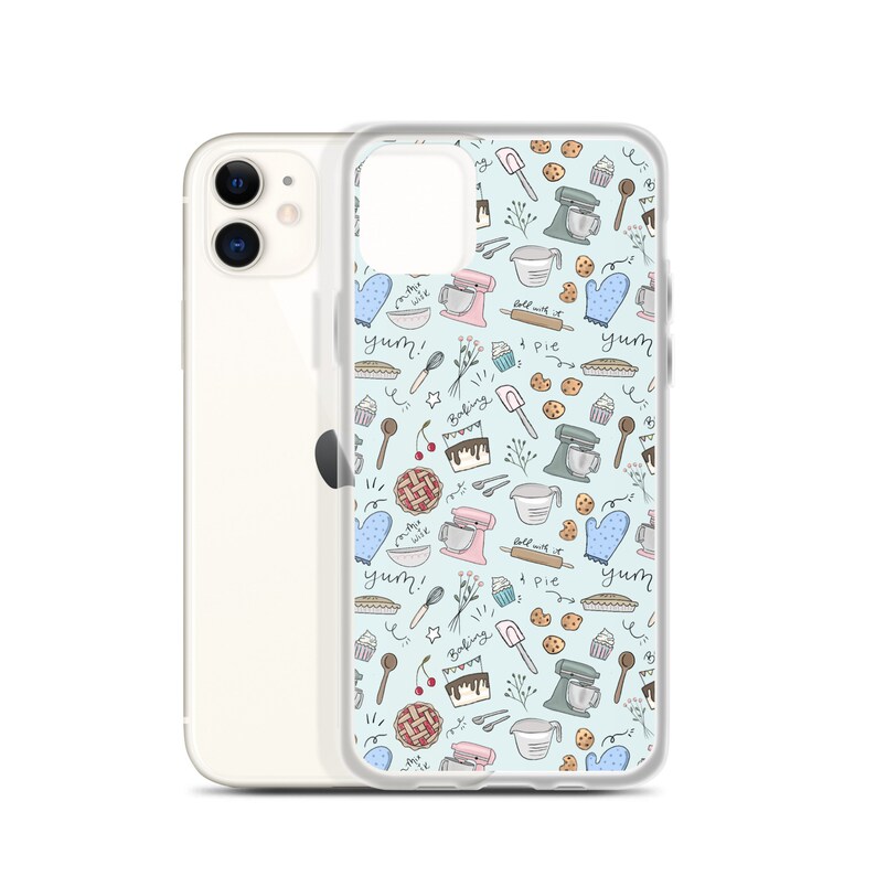 May include: A clear phone case with a light blue background and a pattern of baking-themed illustrations. The illustrations include a mixer, a pie, a cupcake, a rolling pin, a spoon, a cherry, a bowl, and the words "yum!" and "baking".