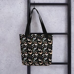 May include: A black tote bag with a repeating pattern of colourful chickens and eggs. The text "Crazy Chicken Lady" is repeated throughout the pattern.