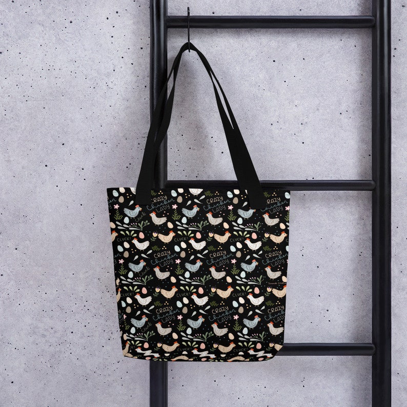 May include: A black tote bag with a repeating pattern of colourful chickens and eggs. The text "Crazy Chicken Lady" is repeated throughout the pattern.