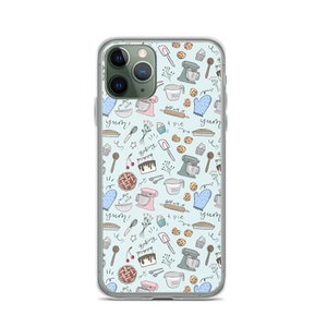 May include: A clear phone case with a light blue background and a pattern of baking-themed illustrations. The illustrations include a mixer, pie, cookies, cherries, and the words "yum!" and "baking".