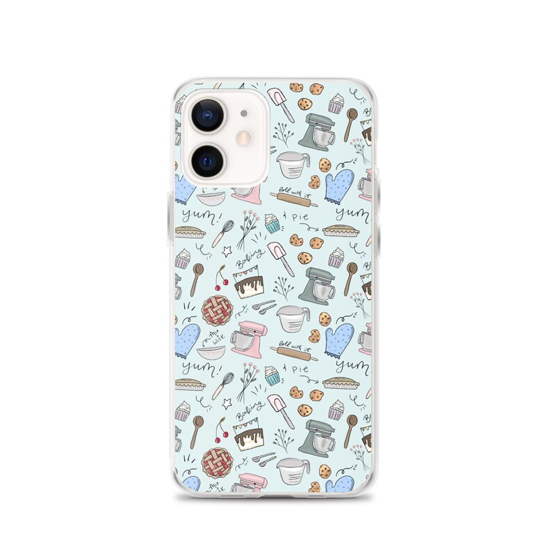 May include: A clear phone case with a light blue background and a pattern of baking-themed illustrations. The illustrations include a mixer, a rolling pin, a pie, a cupcake, a cherry, a spoon, a whisk, and the words "yum!" and "baking".