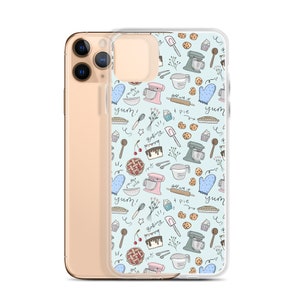 May include: A clear phone case with a light blue background and a pattern of baking-themed illustrations. The illustrations include a mixer, a pie, a rolling pin, a spatula, a whisk, a measuring cup, a measuring spoon, a cupcake, a cherry pie, a cake, a cookie, and the words "yum!" and "baking".