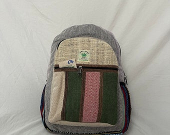 May include: A grey and beige backpack with a front pocket featuring vertical stripes of green, pink, and beige. The backpack has a zip closure and a tag that reads "Himalayan Hemp". The bag is made of a woven material.