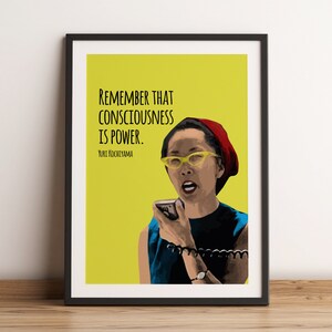 May include: A yellow background with a black framed image of a woman with a red hat and yellow glasses holding a microphone. The text reads "Remember that consciousness is power. Yuri Kochiyama."