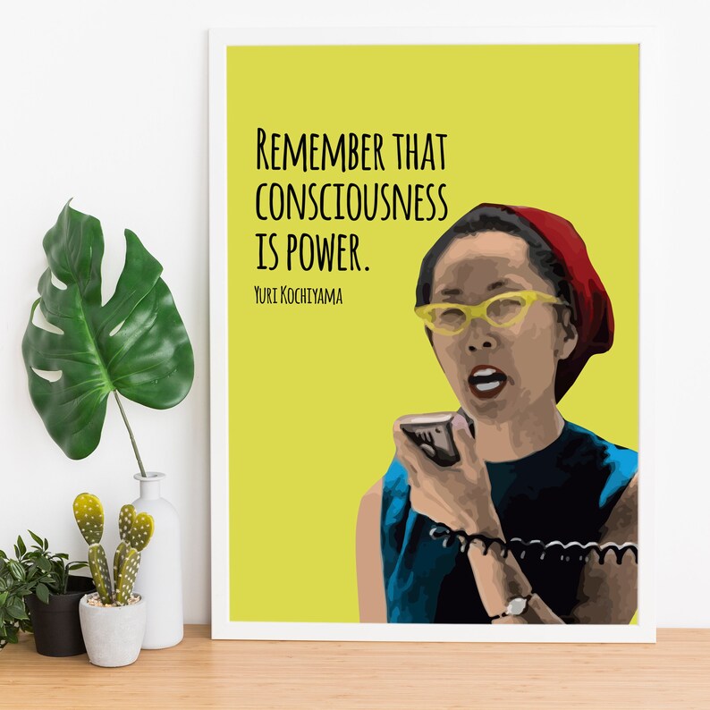 May include: A yellow background with a quote in black text: "Remember that consciousness is power."  The quote is attributed to Yuri Kochiyama. A cartoon illustration of a woman with a red hat and yellow glasses speaking into a microphone.