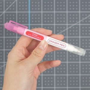 May include: A pink air erasable eraser pen with the words "Pink Air Erasable" and "Eraser Pen" printed on the barrel.