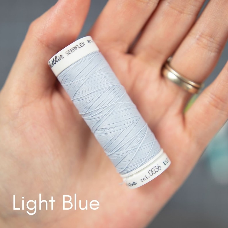 May include: A spool of light blue thread with the text "SERRAFLEX Art. 0036 E.U." on the label.
