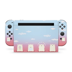 May include: A Nintendo Switch console with a custom skin featuring a sky-themed design. The skin has a gradient of pink and blue with white clouds and cartoon polar bears. The controllers are light blue and pink.