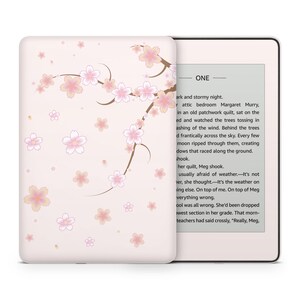May include: A pink and white Kindle Paperwhite e-reader with a floral design on the case. The screen displays the text "ONE" and a short excerpt from a book.